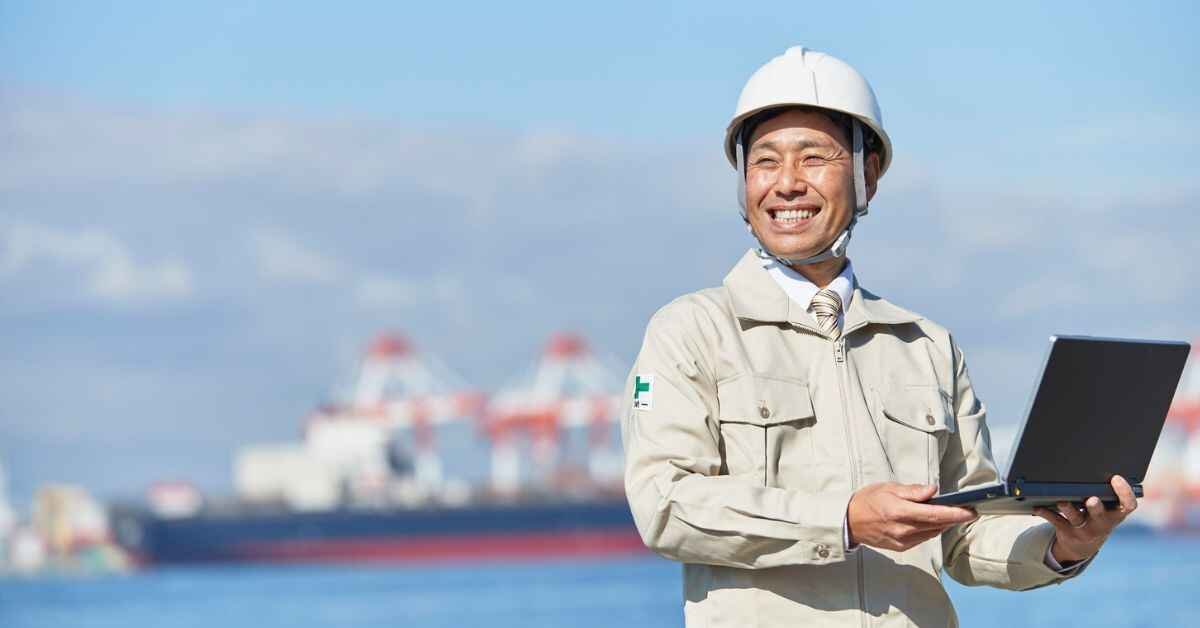 a man is standing and holding a loptop with marinenet