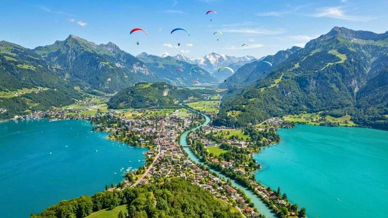 Paragliders flying above Interlaken between Lake Thun and Lake Brienz.
