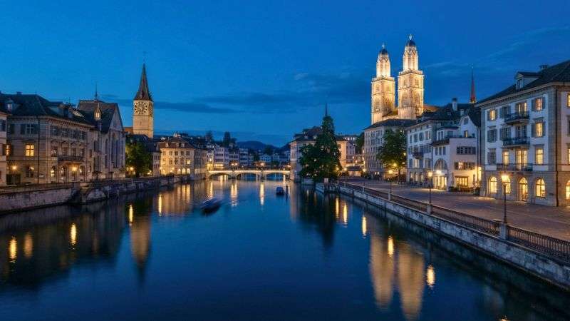 Zurich Old Town beside the Limmat River during blue hour.